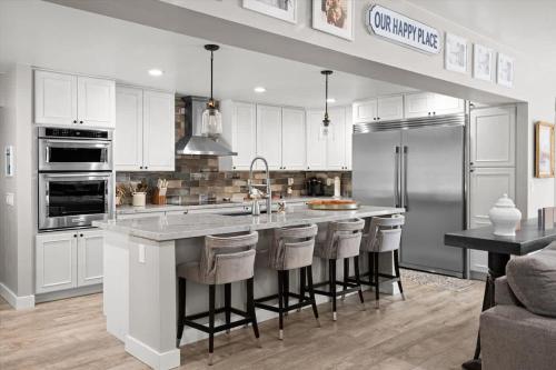 a kitchen with white cabinets and a large island with bar stools at Timberland Hideaway in Payson