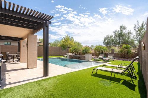 a backyard with a swimming pool and green grass at Superstition Sunrise in Gold Canyon