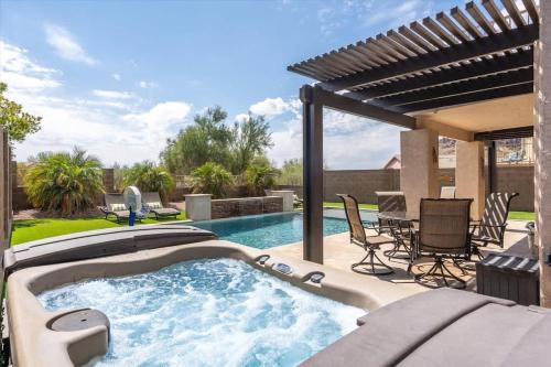 a swimming pool with a patio and a table and chairs at Superstition Sunrise in Gold Canyon