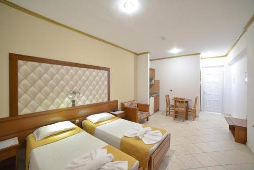 a hotel room with two beds and a table at Angelina Hotel & Apartments in Sidari