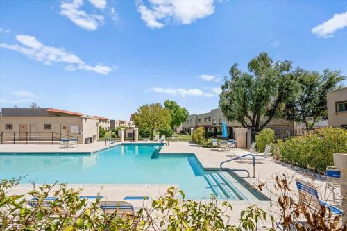a large swimming pool with chairs and trees at Old Town Elegance in Scottsdale
