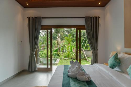 a bedroom with a bed with stuffed animals on it at Wanasari Villa in Tampaksiring