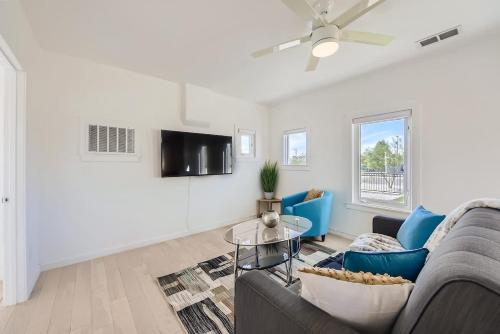 a living room with a couch and a tv at Cosmopolitan Cottage in Phoenix