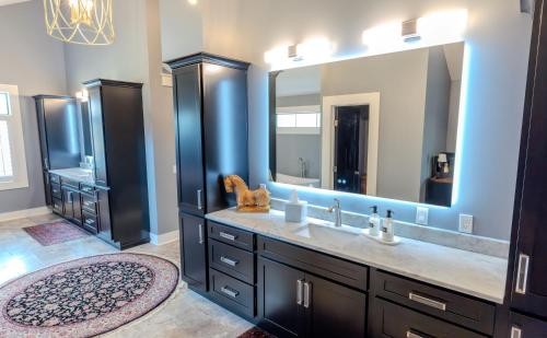 a bathroom with a sink and a large mirror at Whispering Prairie Lodge in Salina