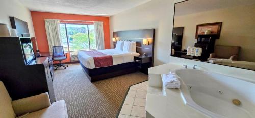 a hotel room with a bed and a bath tub at Grand Plaza Hotel & Conference Center in Branson
