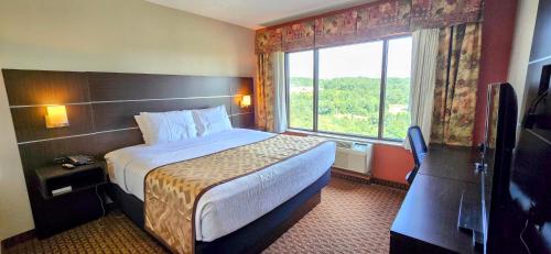 a hotel room with a bed and a large window at Grand Plaza Hotel & Conference Center in Branson