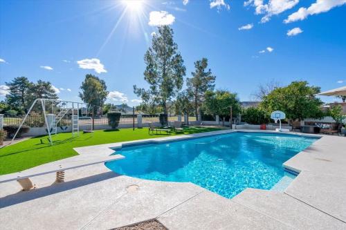 a swimming pool with a basketball hoop and a playground at Live Blissfully in Phoenix