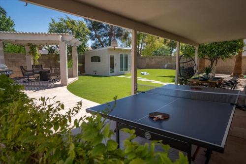 a ping pong table in a yard with a patio at The Seaside Bohemian in Chandler