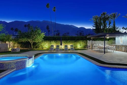 a swimming pool in a backyard with mountains in the background at Palm 57 - Alice Lodging in Palm Springs
