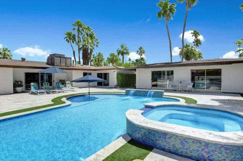 a swimming pool in front of a house at Palm 57 - Alice Lodging in Palm Springs