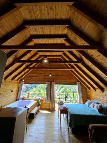 a bedroom with a bed and a tub in a room at cabana Eco da Natureza in Praia Grande