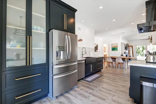 a kitchen with black cabinets and a stainless steel refrigerator at DL882 - Desert Falls Poolside Escape - Alice Lodging in Palm Desert