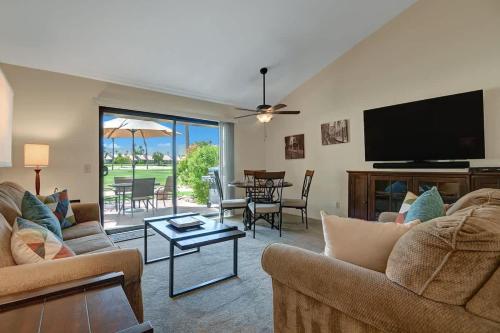 a living room with couches and a flat screen tv at PN561 - Jupiter View - Alice Lodging in Palm Desert