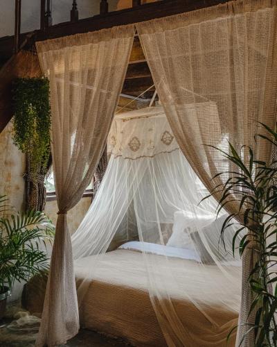 a bedroom with a canopy bed with mosquito nets at Hayag in General Luna