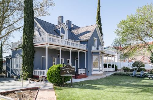 a blue house with a sign in the front yard at The Mulberry Inn -An Historic Bed and Breakfast in St. George