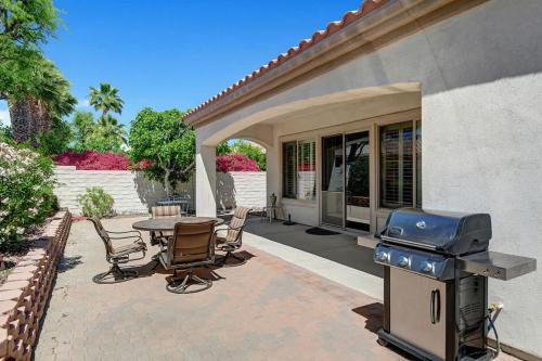 a patio with a grill and a table and chairs at Sun City Fun - Alice Lodging in Indio