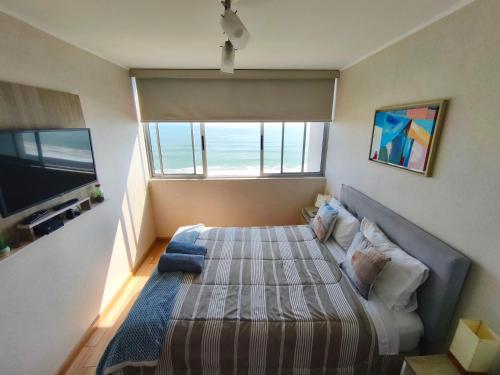 a bedroom with a large bed with a large window at EuVe Ocean View Flat in Lima in Lima
