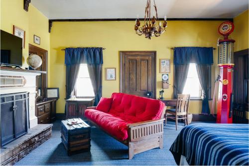 a living room with a red couch and a fireplace at The Mulberry Inn -An Historic Bed and Breakfast in St. George