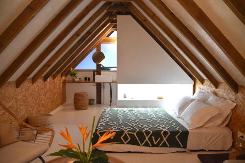 a bedroom with a bed in an attic at Le Fare de la Baleine in Punaauia