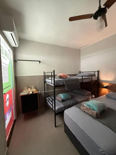 a room with three bunk beds and a tv at Hotel Valle in Patrocínio