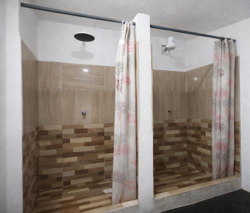 a shower in a bathroom with a shower curtain at Itaúna Surf Camping in Saquarema