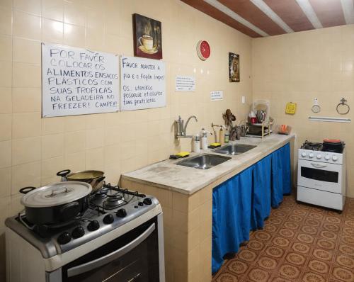 a kitchen with a stove and a sink at Itaúna Surf Camping in Saquarema