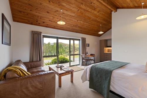 a bedroom with a bed and a couch and a table at Makoura Lodge in Apiti