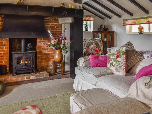 a living room with two couches and a fireplace at The Old Thatch in Hailsham