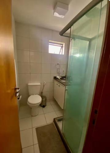a bathroom with a toilet and a glass shower at Ap charmoso in Mossoró