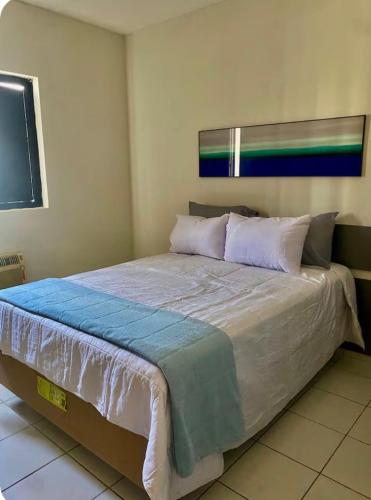 a bedroom with a large bed with white sheets and pillows at Ap charmoso in Mossoró