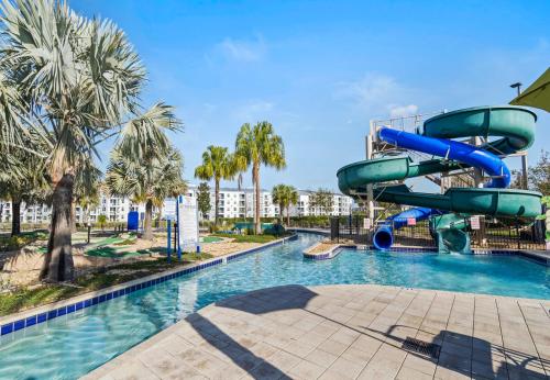 a water slide in a pool at a resort at Beautiful Apartments 5 Minutes away from Disney! in Kissimmee