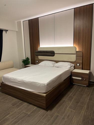a bedroom with a large bed with white sheets at Tara Home 44 in Sheikh Zayed