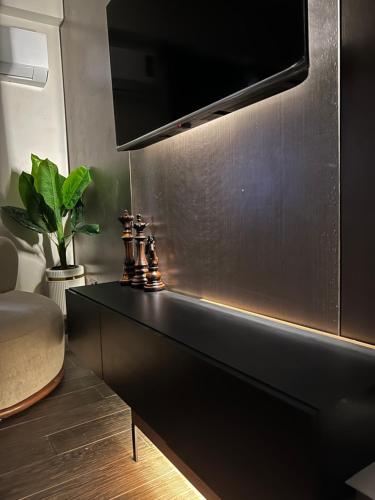 a black dresser with a television on a wall at Tara Home 44 in Sheikh Zayed