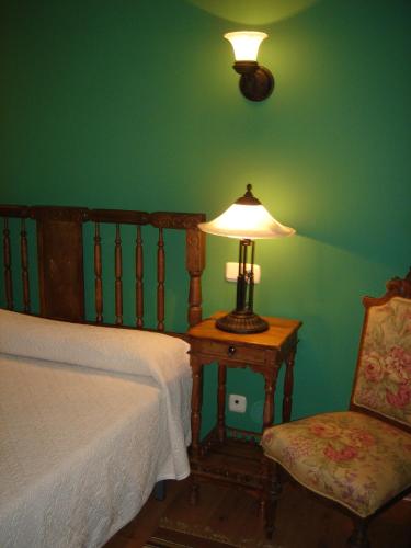 a bedroom with a bed and a lamp and a chair at Fuente de Cella in Cella