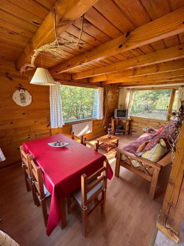 a dining room with a red table in a cabin at Rincon de Ñires cabaña 4 in San Martín de los Andes