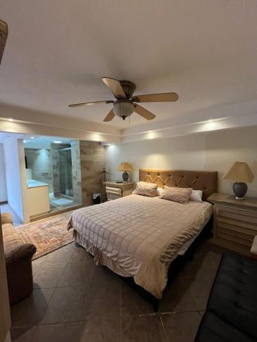 a bedroom with a bed and a ceiling fan at Hotel Vagabundo in Tijuana