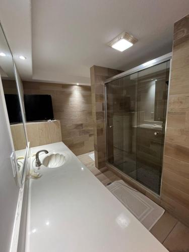 a bathroom with a shower and a white sink at Hotel Vagabundo in Tijuana