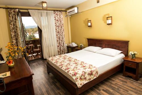 Habitación de hotel con cama y balcón en Pensiunea Siva, en Horezu