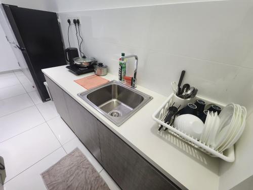 a kitchen counter with a sink and a dish rack at Horizon Rooftop Skypool Condotel - Ipoh in Ipoh