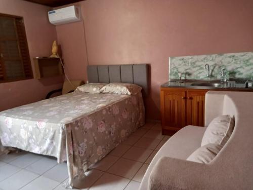 a room with a bed and a sink and a table at kit net Rua Ildo Meneghetti, 160 in Alegrete