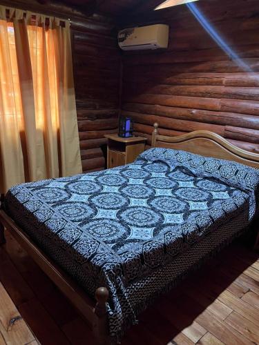 a bedroom with a bed with a wooden wall at Cabañas El Oasis del Peñón in Casa Grande