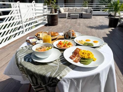 a table with plates of breakfast foods on it at BORÉNA Hotel Boutique in Playa del Carmen