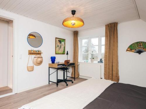a bedroom with a bed and a desk and a window at Nature Escape Forest & Lake Access in Viborg