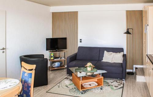 a living room with a blue couch and a tv at Beautiful Apartment In Reifferscheid in Reifferscheid