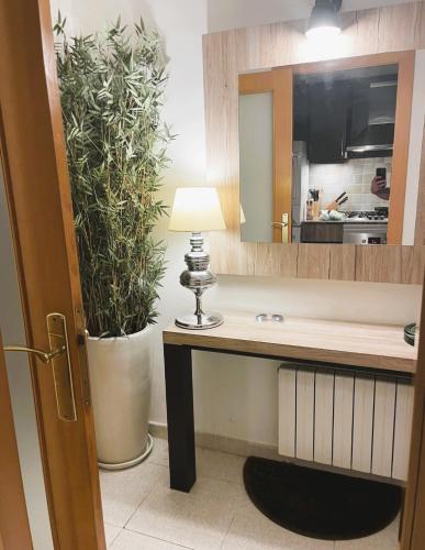a desk with a lamp and a potted plant in a room at Attic Center Sitges in Sitges