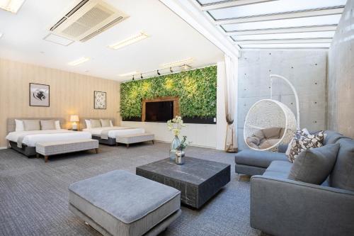 a large living room with couches and a tv at Bijou Suites AI PREMIUM in Osaka