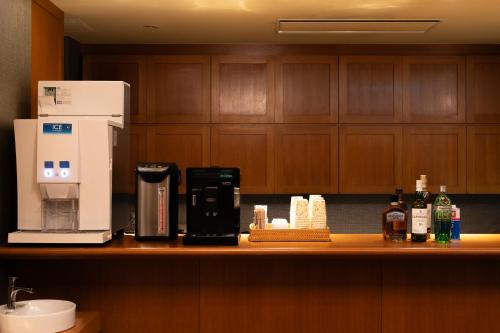 a kitchen counter with a coffee maker and a coffeemaker at Mori-no-Hotel Sendai in Sendai