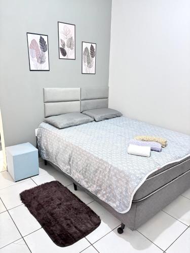a bed in a white room with a white floor at Apartamento Confortável Próx Unesp in Botucatu