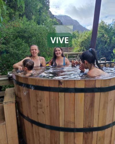 a group of people bathing in a hot tub at Parque Guaiquivilo, Cabañas de montaña con tinaja privada in Colbún