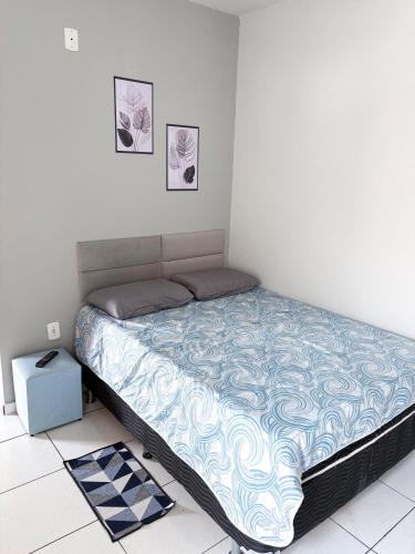a bed in a white room with at Apartamento Confortável Próx Unesp in Botucatu